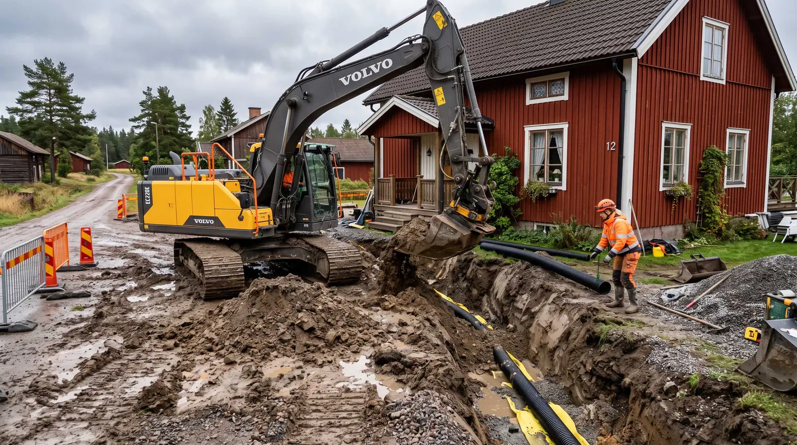 Grävmaskin dränerar runt ett rött hus utanför Umeå