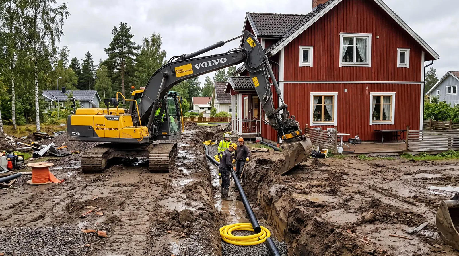 Två arbetare lägger dräneringsrör i schakt